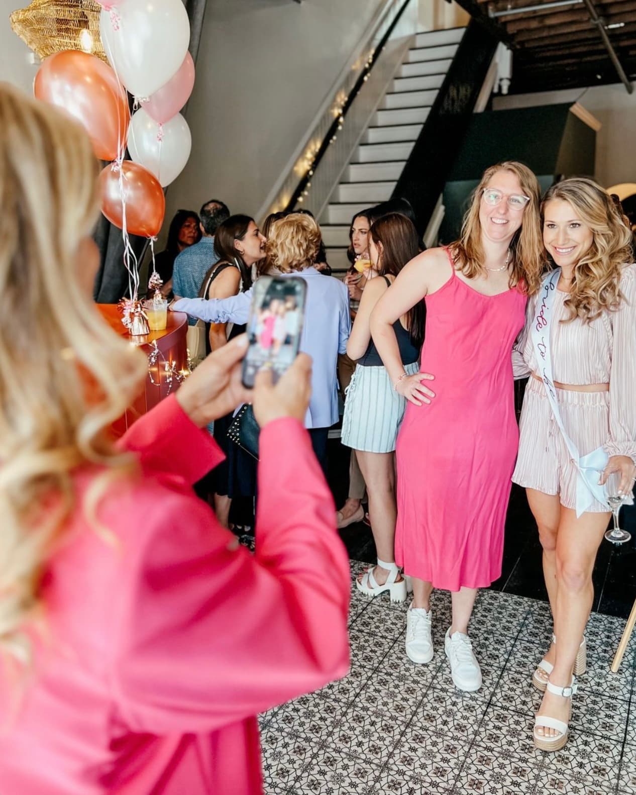 Friends celebrating a bachelorette party with balloons at Wax + Wine